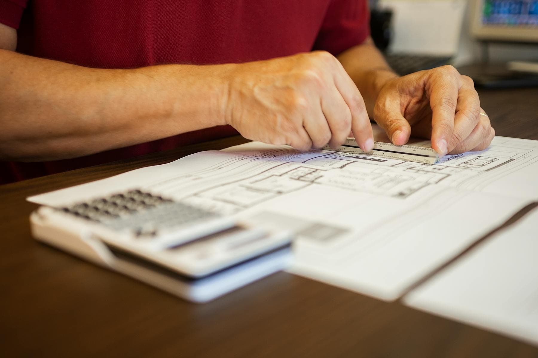 Close-up of ruler and blueprint review on a desk