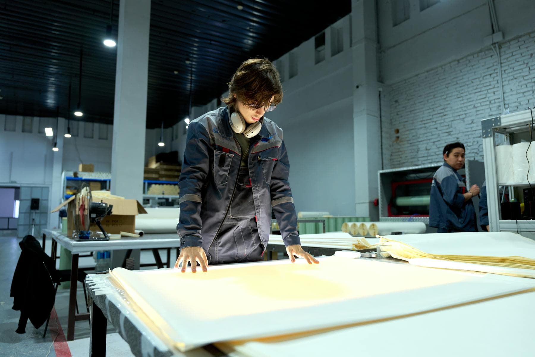 Industrial worker examining sheets in a factory environment
