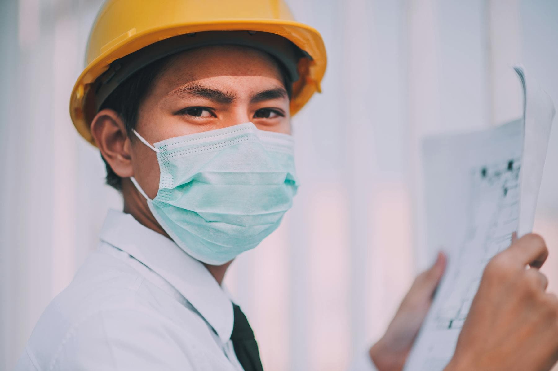 Engineer examining blueprints outdoors