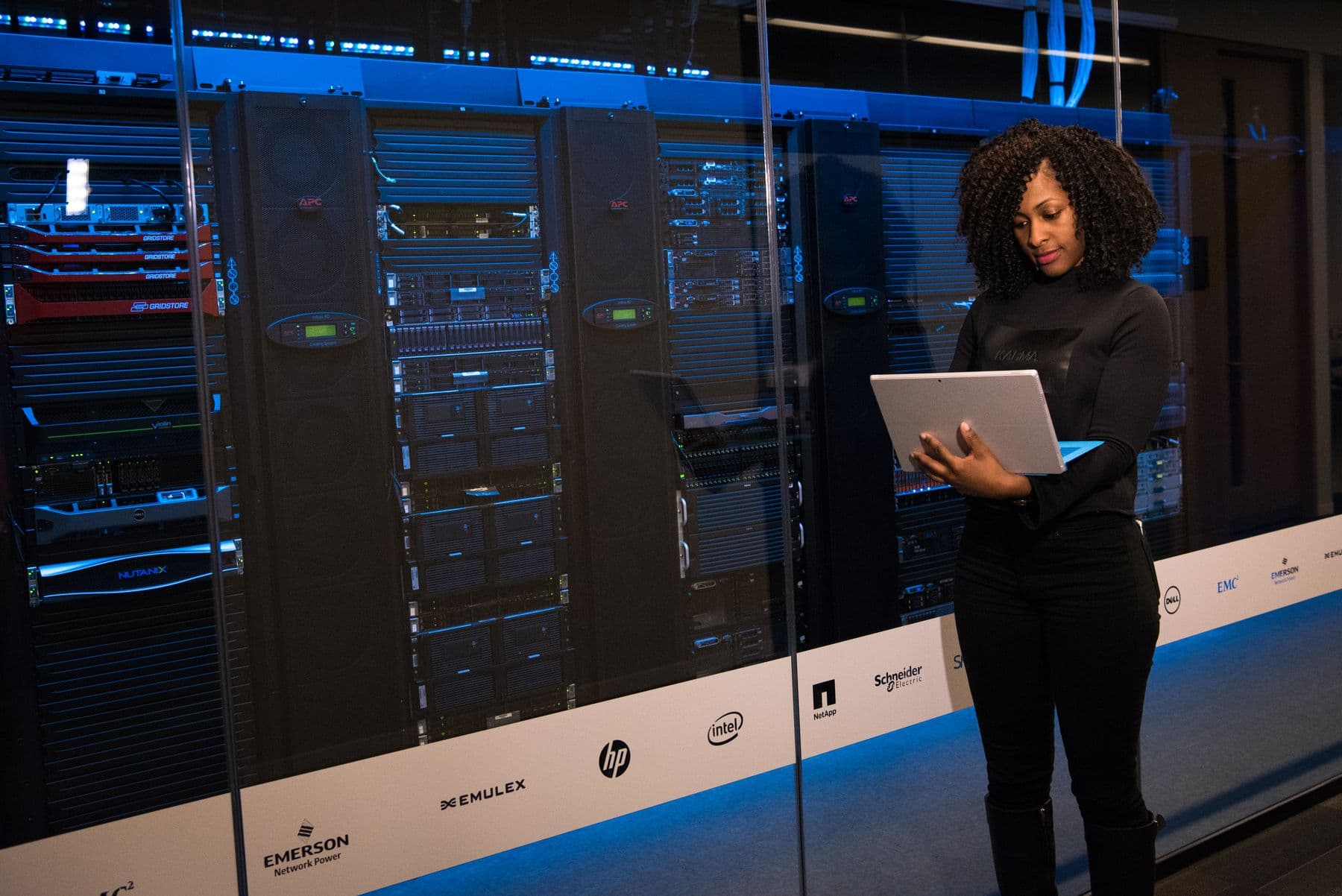 Engineer using laptop while monitoring data servers