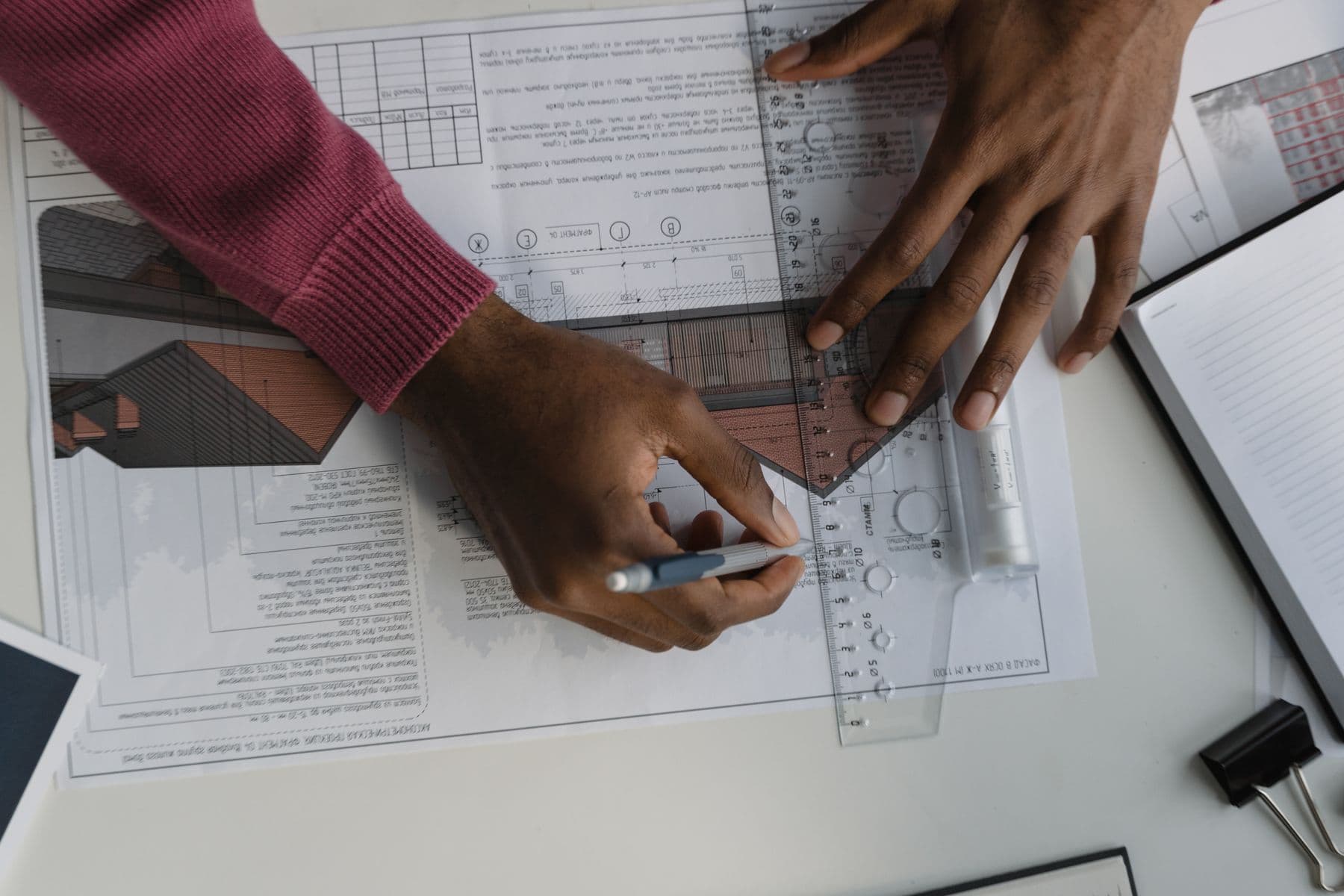 Architect sketching blueprints with ruler at desk
