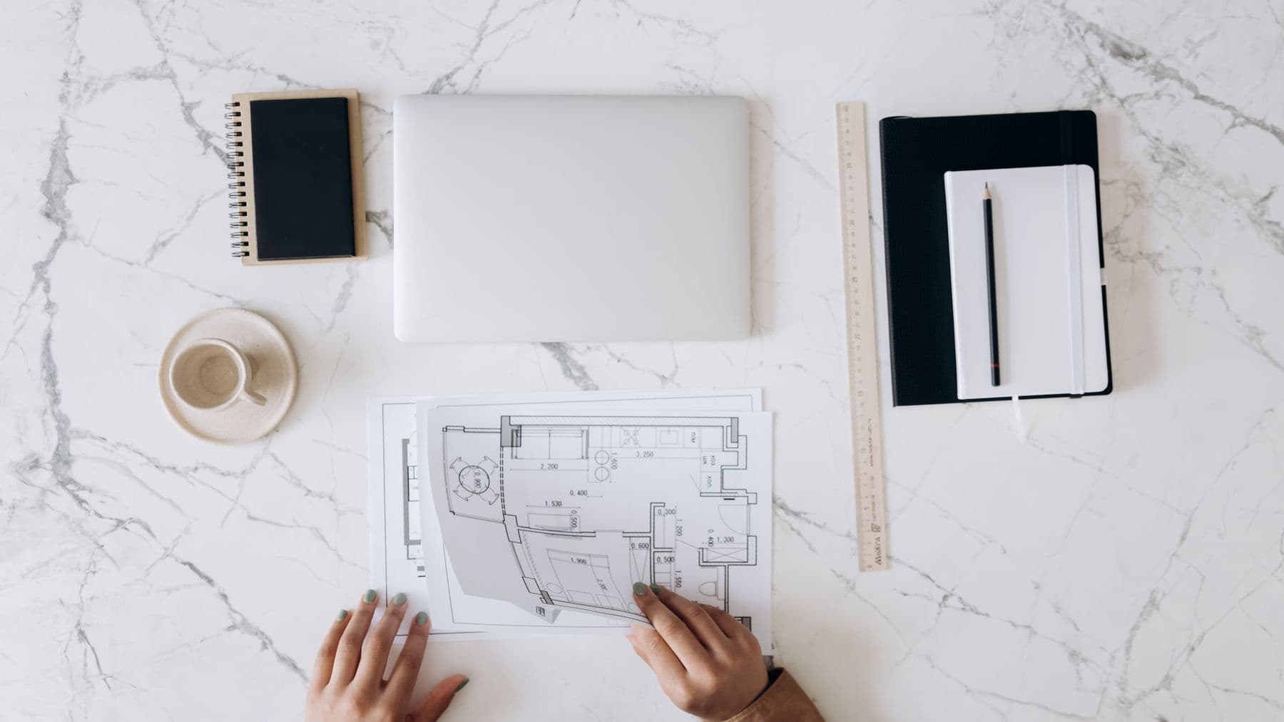Architect work table with laptop, blueprints, notebook, and tools