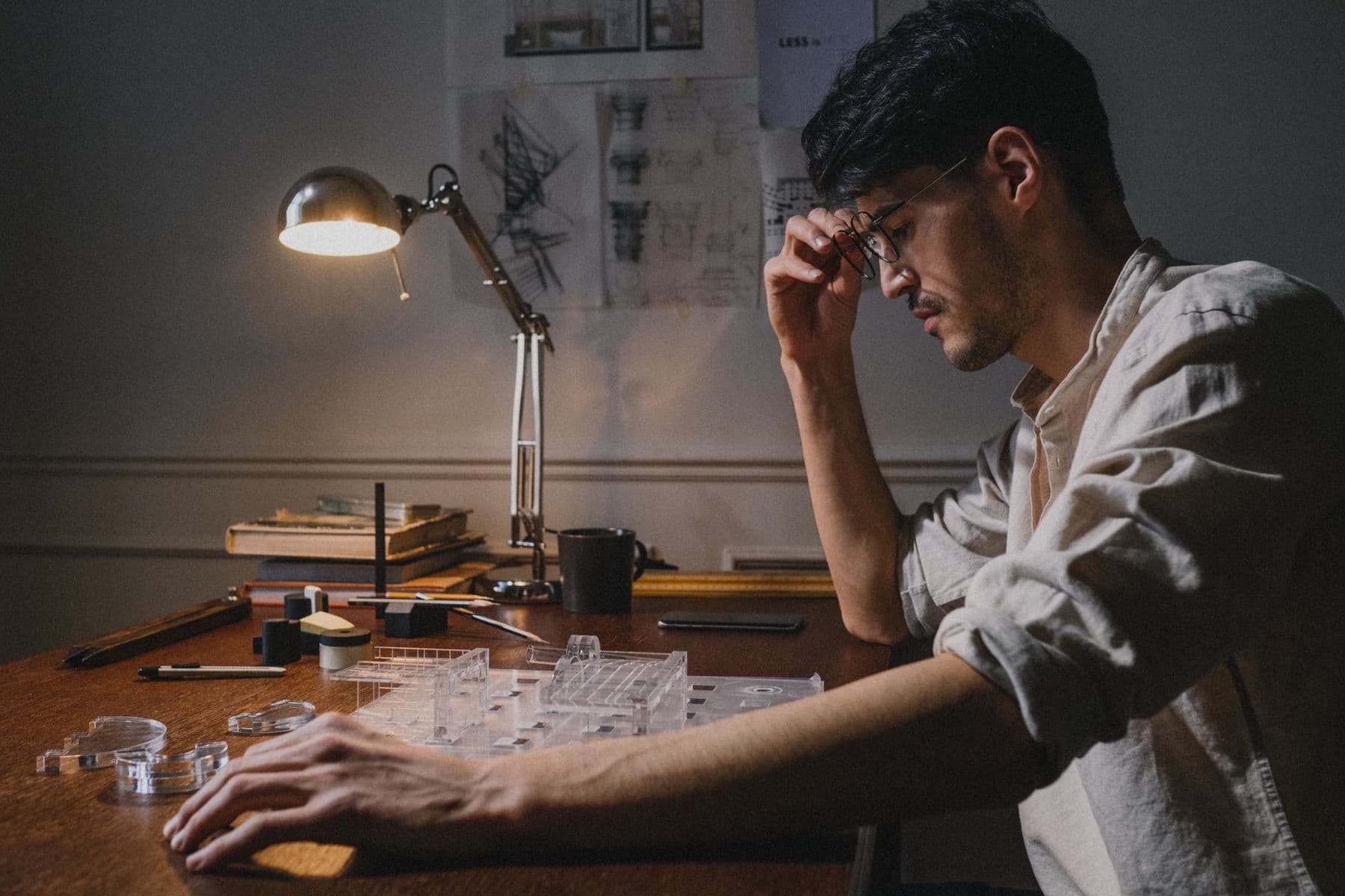 Architect working at a desk on a model under a lamp